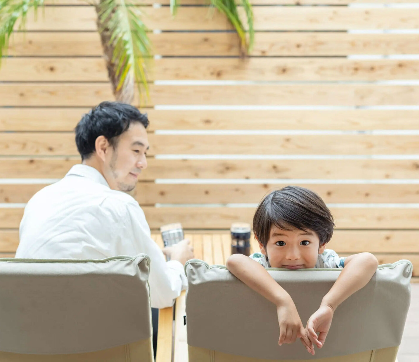 ウッドデッキでくつろぐ父と息子